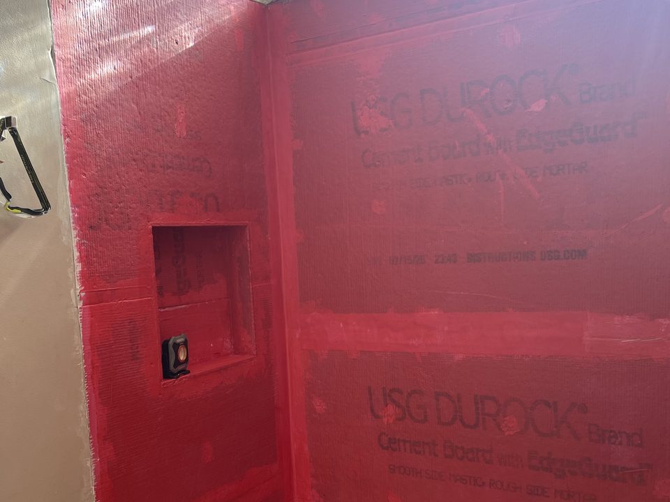 Waterproofing membrane and cement board installed before tiling, with the niche framed in